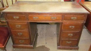An Edwardian mahogany desk with a rectangular moulded top above a central drawer and two banks of