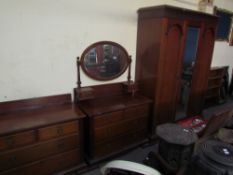 An Edwardian mahogany matched three piece bedroom suite comprising a triple wardrobe,