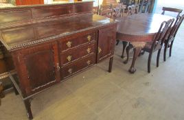 A 20th century mahogany extending dining table with four chairs and a matching sideboard,