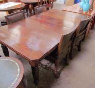 An Edwardian walnut extending dining table on tapering legs,
