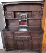 A 20th century oak dresser with a shelved and cupboard top, the base with drawers and cupboards