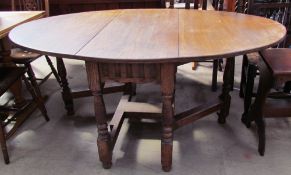 A 20th century oak gate leg table with drop flaps on turned legs