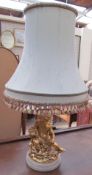 A table lamp, the base with a gilt cherub holding a chalice on a circular base