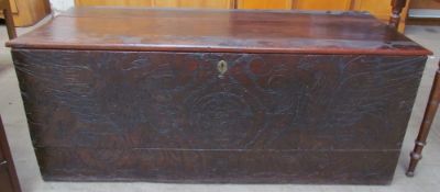 A 17th century hardwood coffer, with a planked top above a chip carved front depicting eagles and
