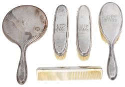 A George V silver backed five piece dressing table set
