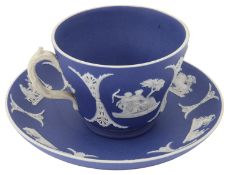 A 19th century Wedgwood tea cup and saucer in white on dark blue dipped jasperware