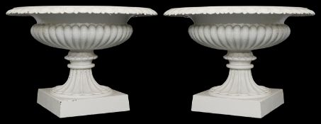 A pair of Victorian white painted cast iron garden urns