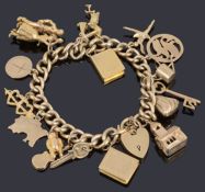 A 9ct gold hollow curb link bracelet with padlock and seventeen assorted gold charms