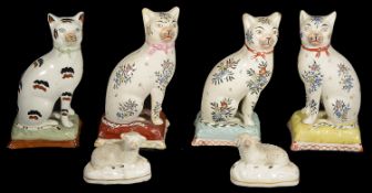 Four early 19th Century Staffordshire pottery cats and a pair of small recumbent sheep