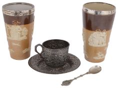 A late 19th c Indian Kutch silver teacup and saucer and two silver mounted Doulton stoneware beakers