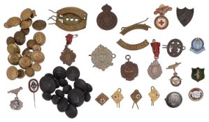 A collection of military buttons, fobs and cap badges