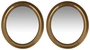 A pair of late 19th/early 20th century gilt brass framed oval mirrors (2)
