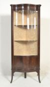 An Edwardian mahogany display cabinet, free standing and enclosed by a single serpentine shaped