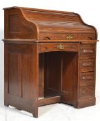 An early 20th Century oak tambour fronted roll top single pedestal desk, the roll top opening to