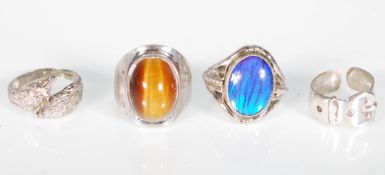 A group of three silver rings to include a hallmarked ring set with a large cabochon tigers eye