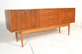 A 1970's retro vintage Uniflex teak wood sideboard credenza having a central bank of three drawers