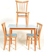 A vintage mid 20th Century dining table having flared top raised on tapering beech supports together