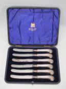 A boxed set of early 20th Century Mappin and Webb silver handled knives having scrolled shell design