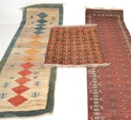 A collection of  20th century rugs to include a large red ground Persian runner with geometric