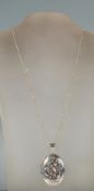 A silver hallmarked ladies chase decorated oval locket and silver necklace chain. Birmingham