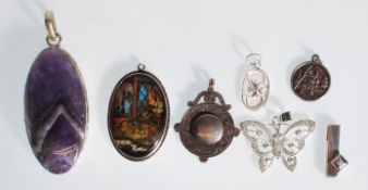 A selection of silver pendants to include an oval pendant set with butterfly wing depicting a