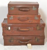 A stack of four vintage early 20th century leather suitcases / trunks to include various sizes,