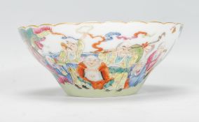 A 20th Century Chinese famille rose porcelain bowl being hand painted with immortals, depicting 18