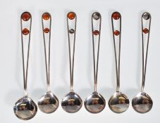 A group of six 20th Century silver spoons having split wire work handles set with amber cabochons.