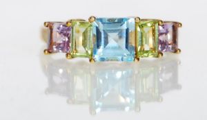 A 9ct gold hallmarked ladies dress ring set with five multi coloured gemstones in a prong setting.