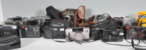 A collection of various cameras and lenses to include Topcon Unirex having a UV Topcor lens and a