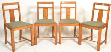 A set of four 20th Century Art Deco oak splat back dining chairs, drop in seat pads raised on square
