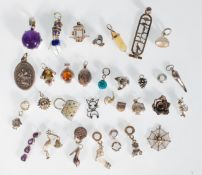 A selection of silver charms and pendants to include a purple stone pendant, a stork charm, a