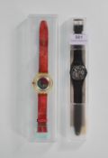 Two swatch wrist watches to include one on a black rubber strap with white roman numerals to the
