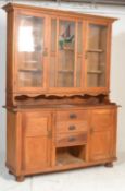A 1920's Art Nouveau oak dresser / sideboard buffet being raised on bun feet with a series of