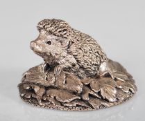 A silver hallmarked figure of a hedgehog raised on a moulded leaf base. Hallmarked for Birmingham