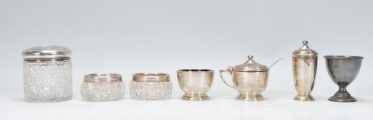 A selection of silver hallmarked cruet items to include a lidded mustard pot, table salt and