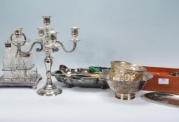 A collection of silver plated items to include a candelabra, cut glass cruet and stand, footed bowl,