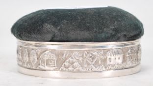 An early 20th Century J Boseck and Co silver hallmarked pin cushion having repousse decoration of