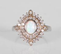 A silver ladies dress ring set with a central opal panel having a double halo of CZ's. Stamped