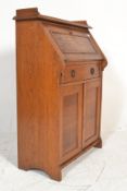An early 20th Century Arts and crafts oak students bureau bookcase, gallery back with fall front
