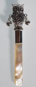 A silver babies rattle in the form owl having a mother of pearl handle. Gross weight 14.8g. Measures