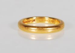 A hallmarked 22ct gold wedding band ring of simple form. Hallmarked Birmingham 1936, marked WM and