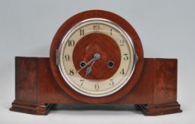 A 1930's Art Deco walnut mantel clock with silvered chapter ring, faceted hands set within an
