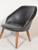 A retro style tub egg chair of Scandinavian influence, the chair upholstered in a black