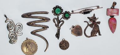 A selection of silver brooches and pendants to include a zig zag design brooch, a heart locket