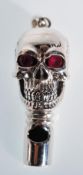 A silver whistle in the form of a skull set with red stone eyes. Gross weight 16.6g. Measures 4.