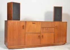 A large retro mid 20th Century stereogram sideboard / credenza being raised on castors with a series