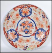 A large 18th /19th Century Chinese export Imari pattern charger decorated with bold vase of