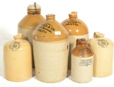 A collection of early 20th century stoneware advertising flagons. Of various shapes and sizes in two
