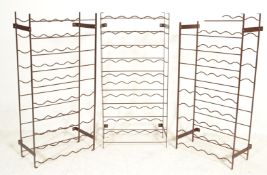 A collection of 3 20th century strapwork metal wine racks. Each rack in original burgandy